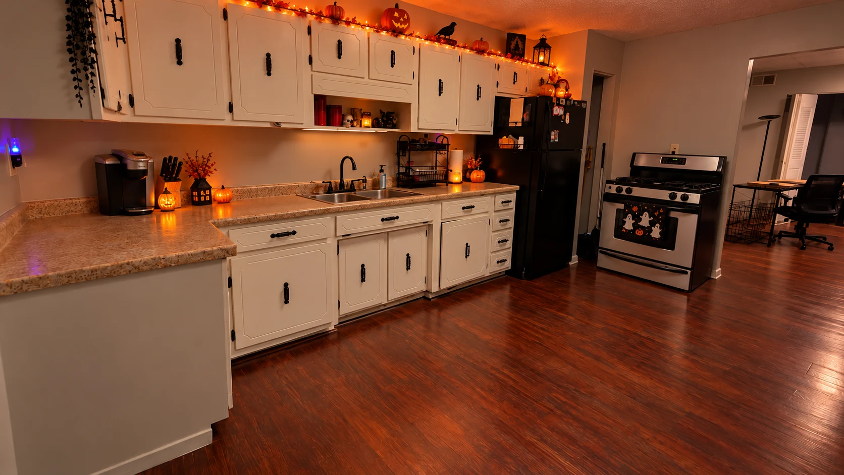 Clean family kitchen with white cupboards and warm wooden flooring