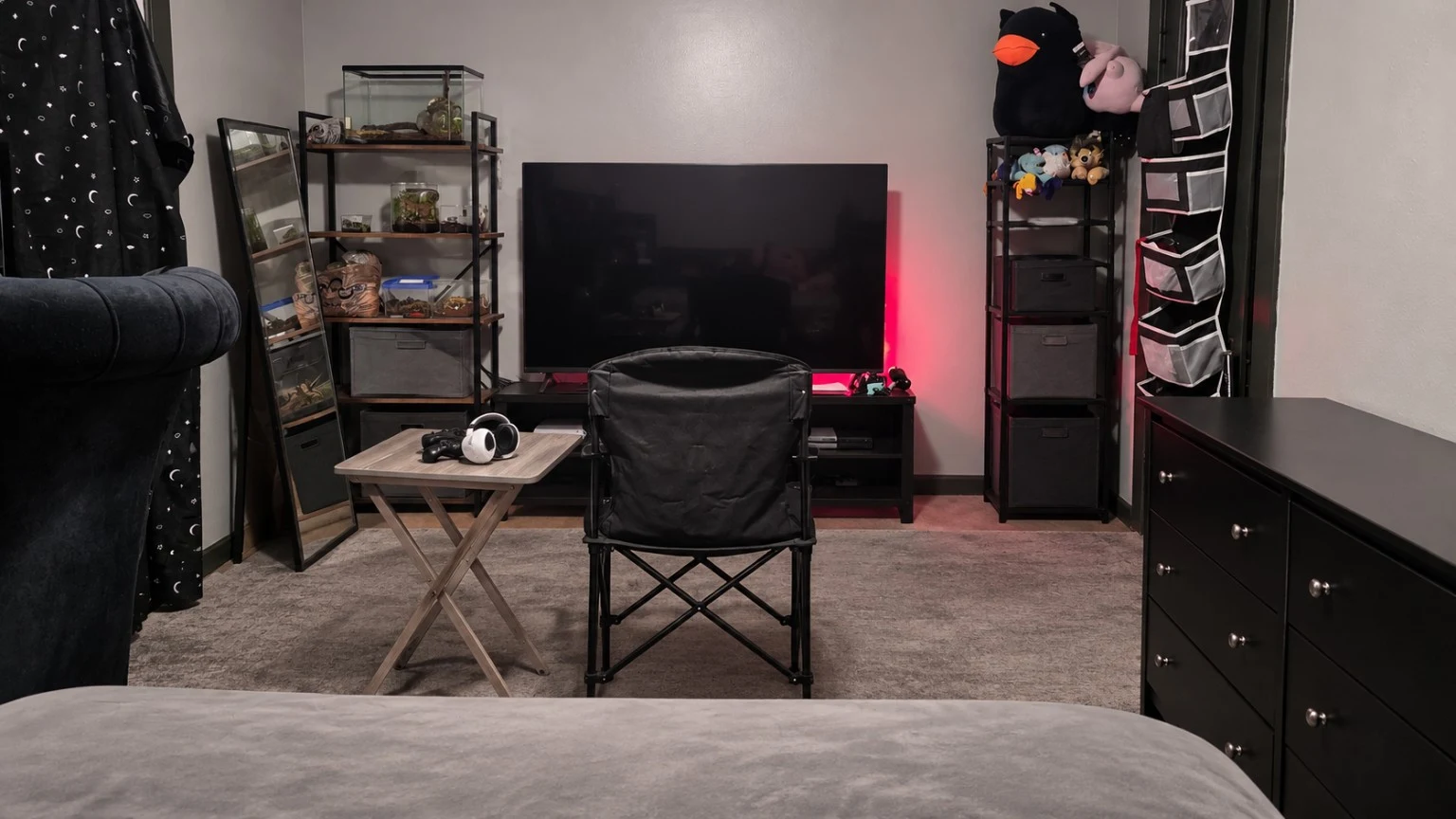 The cozy upstairs bedroom seen from the bed toward the television and seating area